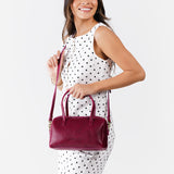 Orchid Large | Model wearing mini duffle shaped handbag with crossbody strap