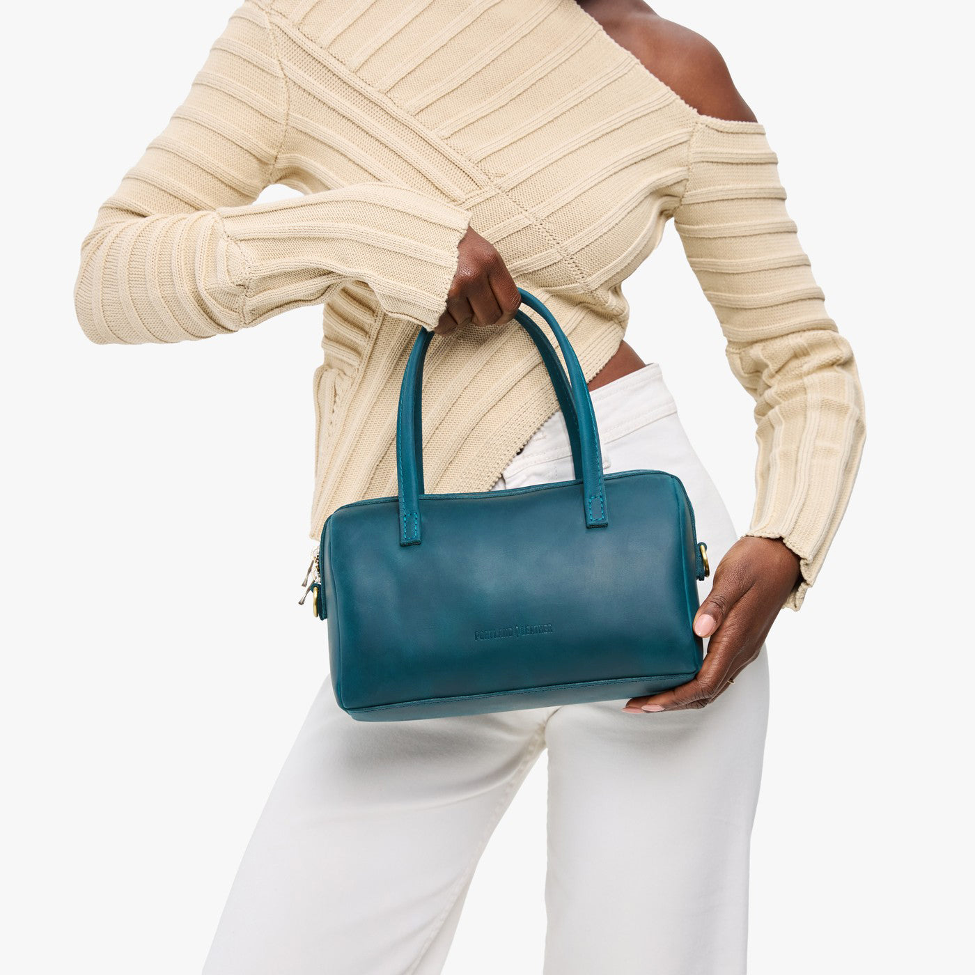 Westward Blue*Large | Model holding mini duffle shaped handbag with crossbody strap