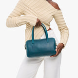 Westward Blue Large | Model holding mini duffle shaped handbag with crossbody strap