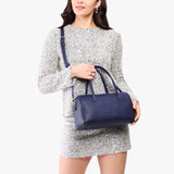 Cobalt Oversized | Model holding mini duffle shaped handbag with crossbody strap