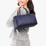 Cobalt Oversized | Model holding mini duffle shaped handbag with crossbody strap