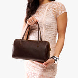 Coldbrew Oversized | Model holding mini duffle shaped handbag with crossbody strap