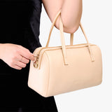 Moonflower Oversized | Model holding mini duffle shaped handbag with crossbody strap