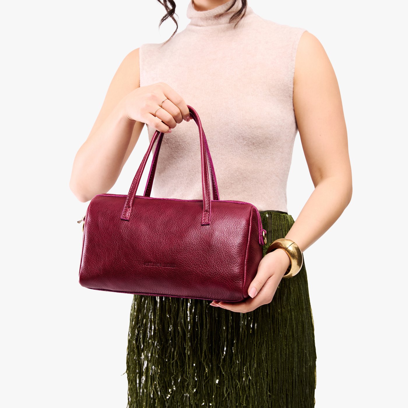 Orchid*Oversized | Model holding mini duffle shaped handbag with crossbody strap