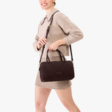 Velvet Brown Oversized | Model holding mini duffle shaped handbag with crossbody strap
