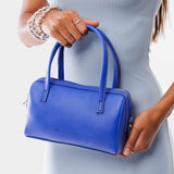 Astro Blue Small | Model holding mini duffle shaped handbag with crossbody strap