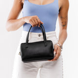 Black Small | Model wearing mini duffle shaped handbag with crossbody strap