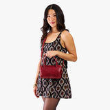 Chili Red Small | Model holding mini duffle shaped handbag with crossbody strap