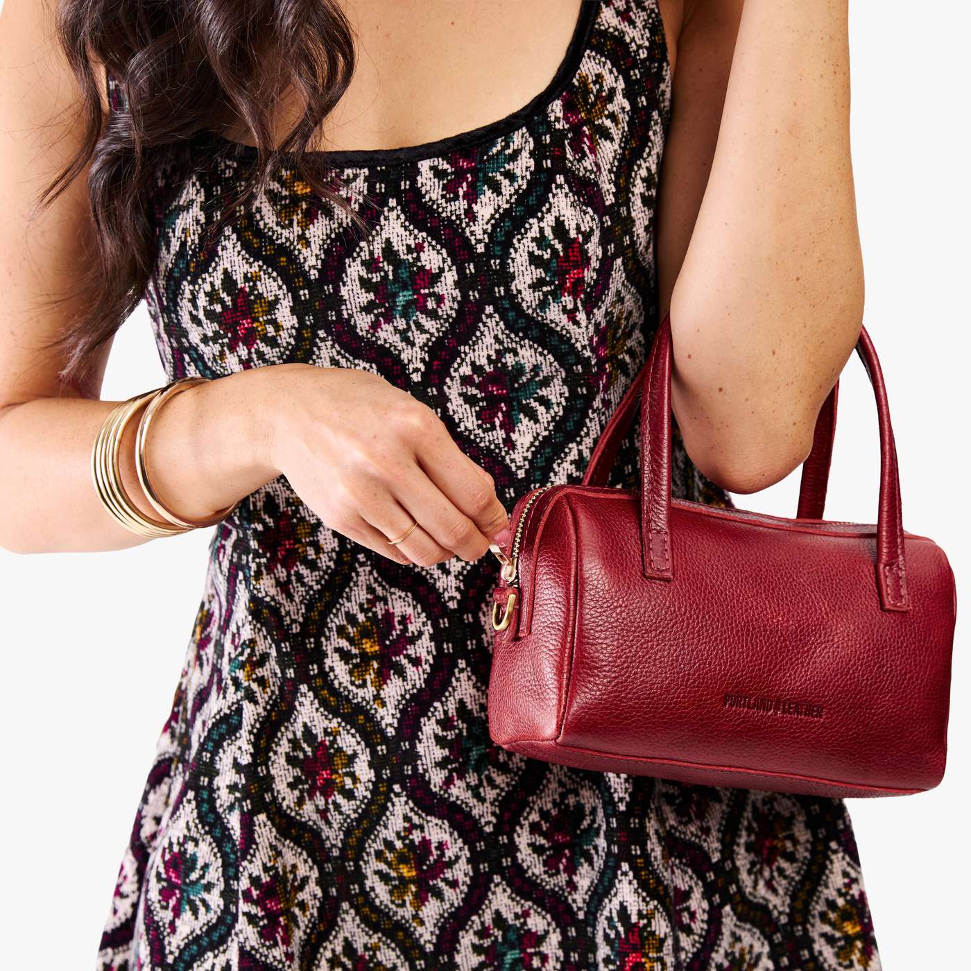 Chili Red*Small | Model holding mini duffle shaped handbag with crossbody strap