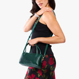 Forest Green Small | Model holding mini duffle shaped handbag with crossbody strap