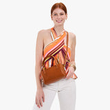 Honey Small | Model holding mini duffle shaped handbag with crossbody strap