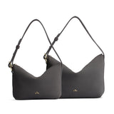 Smoke Grey | Size comparison shot of small and large slouchy leather shoulder bags with zipper opening and three metal tree emblems