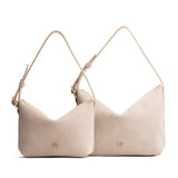 Taupe | Size comparison shot of small and large slouchy shoulder bags with zipper opening and three metal tree emblems
