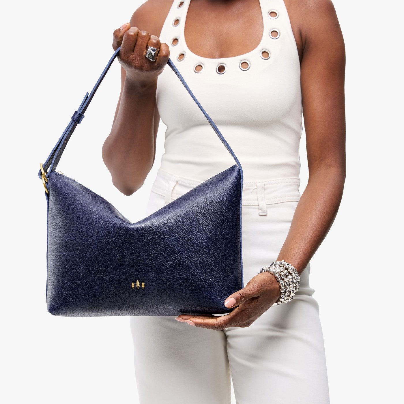 Cobalt*Large | Model Wearing medium sized slouchy leather shoulder bag with zipper opening and three metal tree emblems