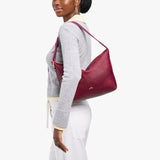 Orchid Large | Model Wearing medium sized slouchy leather shoulder bag with zipper opening and three metal tree emblems