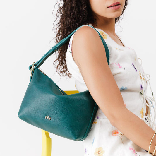 Sea Glass*Small | Model wearing petite slouchy leather shoulder bag with zipper opening and three metal tree emblems