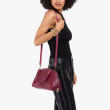 Orchid Small | Model holding a half circle crossbody bag with handles and removable crossbody strap 