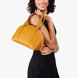 Sunshine Small | Model holding a half circle crossbody bag with handles and removable crossbody strap 