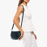 Boreal Small | Model wearing a petite leather Crossbody with a flap and magnetic closure
