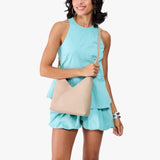 Toasted Oat Small | Model holding petite shoulder bag with adjustable strap and magnetic snap closure