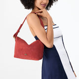 Cinnabar Small | Model holding a Slouchy Shoulder Bag that has a zipper opening and three metal tree emblems