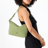 Laurel Small | Model holding a Slouchy Shoulder Bag that has a zipper opening and three metal tree emblems