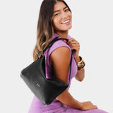 Pebbled--black Small | Model holding petite slouchy leather shoulder bag with zipper opening and three metal tree emblems