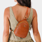 Sienna | Model wearing small sling bag with zipper closure and adjustable strap