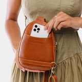 Sienna | Model wearing small sling bag with zipper closure and adjustable strap