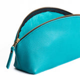 Baja | Spacious leather makeup bag with curved seams and top zipper open