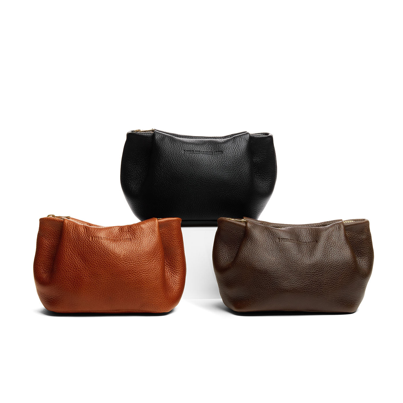 All Variants | Three leather makeup bags with folded sides and zipper closure