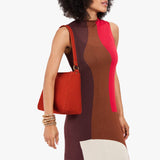 Paprika Small | Model holding a triangular shoulder bag with antiqued brass finished 