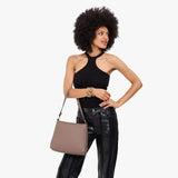 Sparrow Small | Model holding a triangular shoulder bag with antiqued brass finished 