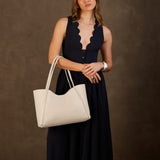 Pebbled Bone Large | Model holding midsize rectangular tote bag