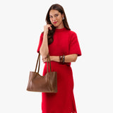 Asheville Medium | Woman in a red outfit holding wide tote with leather straps and snap closure
