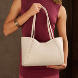 Pebbled Bone Medium | Model holding midsize rectangular tote bag