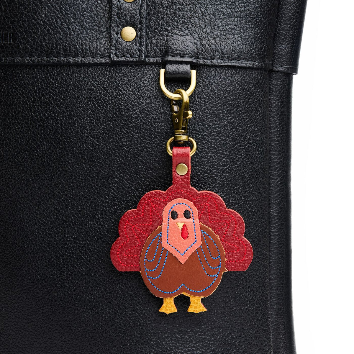 Virgil | A turkey-shaped keychain hanging on a pebbled black bag