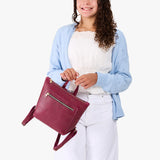 Orchid | Model wearing a petite square slim leather tote backpack with zipper closure and adjustable straps