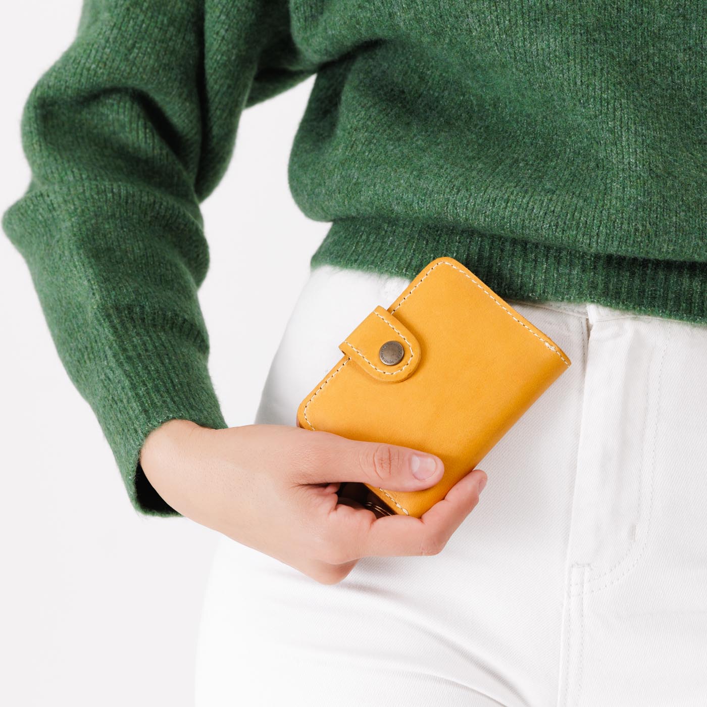 Sunflower | Model holding small leather bifold wallet with snap closed