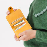 Sunflower | Model holding small leather bifold wallet with snap open