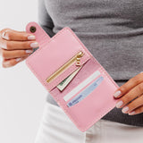 Vintage Pink | Model holding small leather bifold wallet with snap open