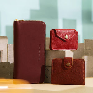 Three wallets on a textured surface with a light blue background