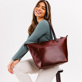 Cognac Zipper | Model holding large zipper leather tote bag with sturdy bridle handles and front pocket
