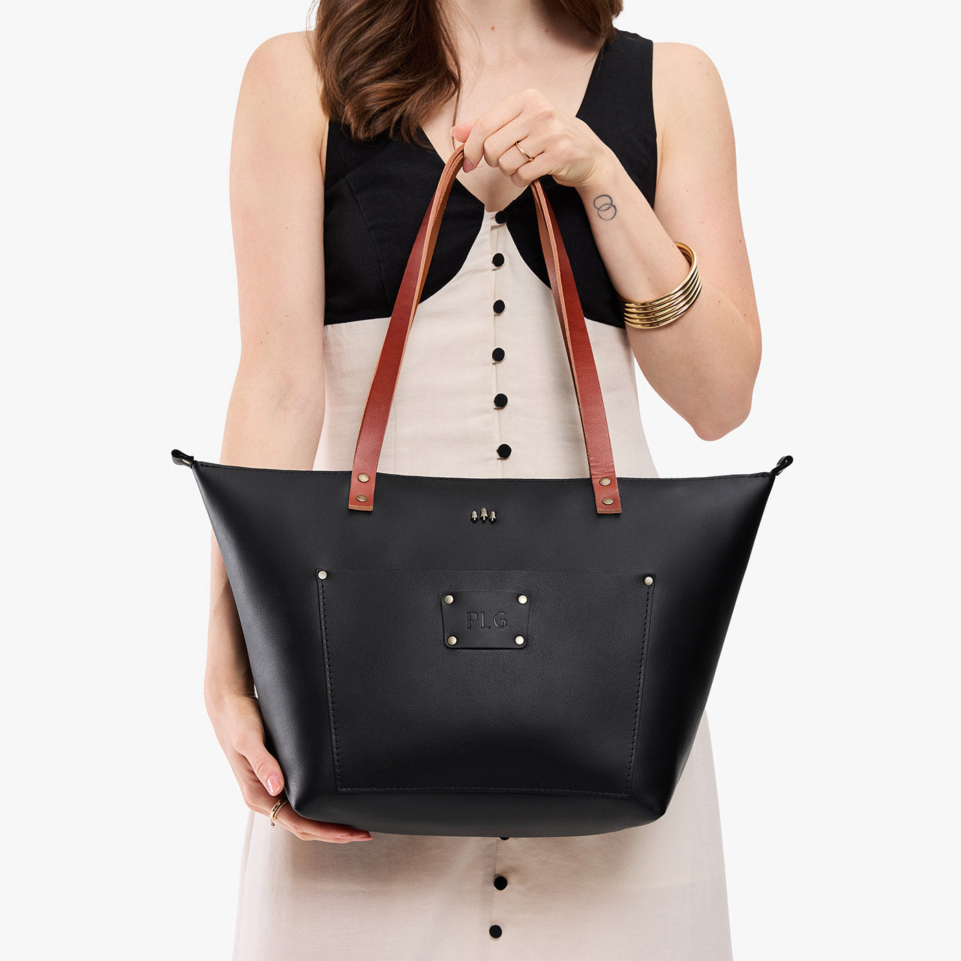 Black*Zipper | Leather Tote Bag with bridle leather handles and monogram plate being held by a model