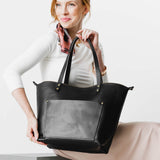 Black Zipper | Model holding large zipper leather tote bag with sturdy bridle handles and front pocket