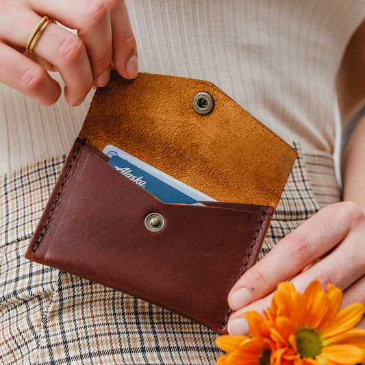 Cognac | Model holding small leather envelope card wallet open