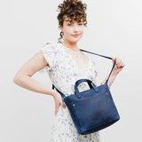 Deep Water Zipper | Model holding crossbody tote bag with zipper closure and front pocket