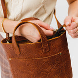 Meadow Zipper | Model holding crossbody tote bag with zipper closure and front pocket